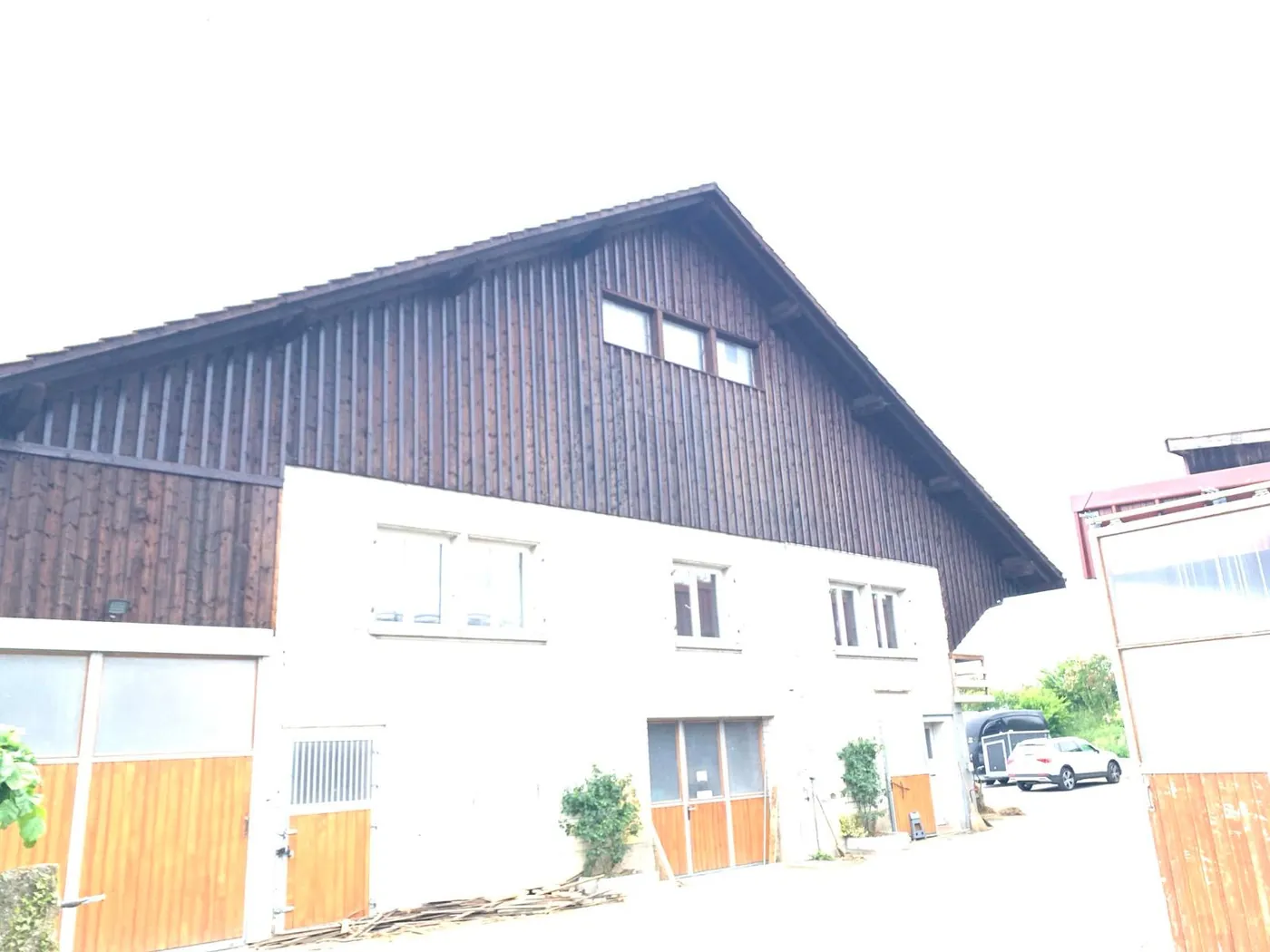 La même ferme après travaux : façade blanche et encadrements nets.