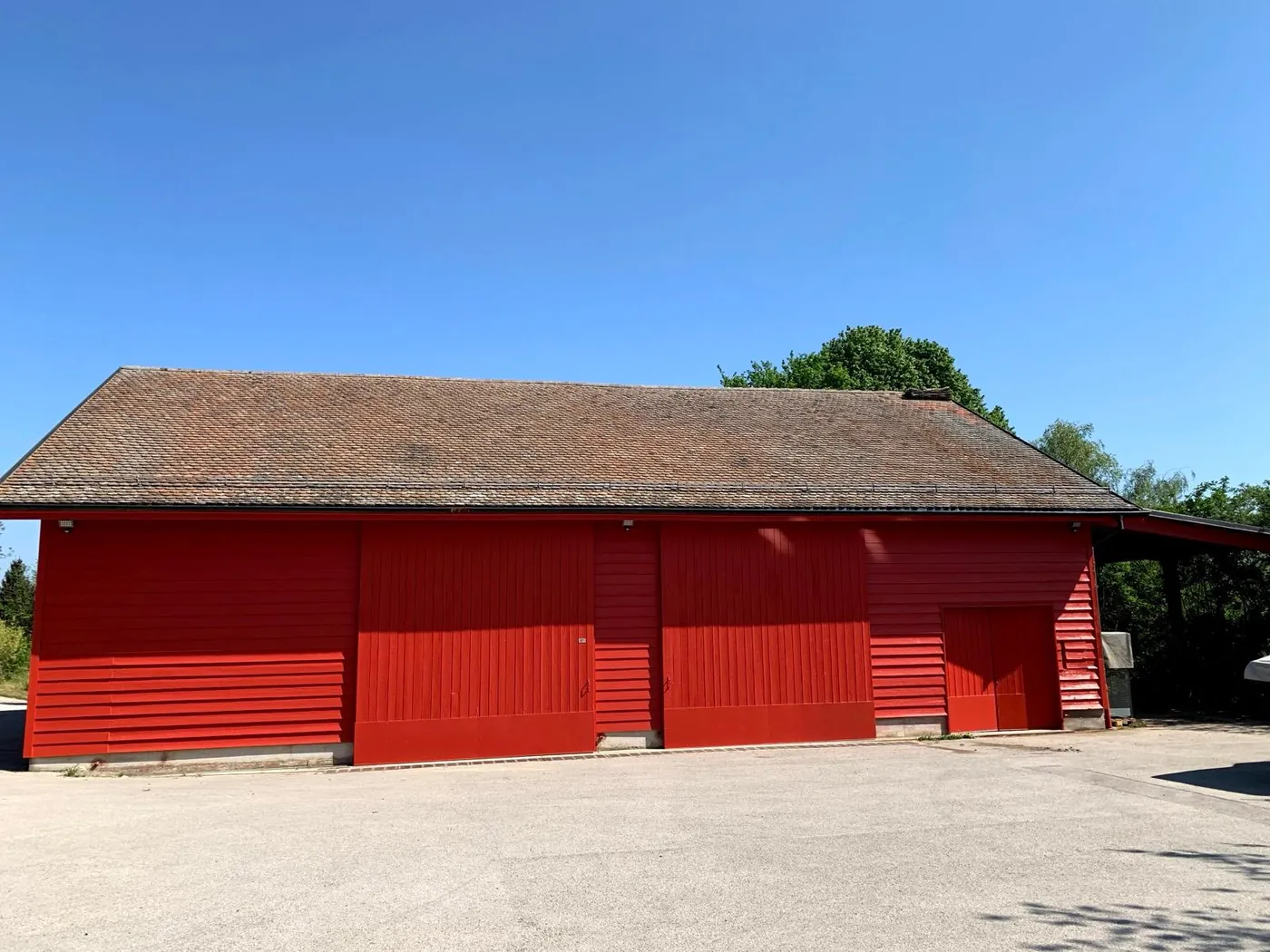 Le même rural après travaux : bardage repris et remis en teinte rouge.