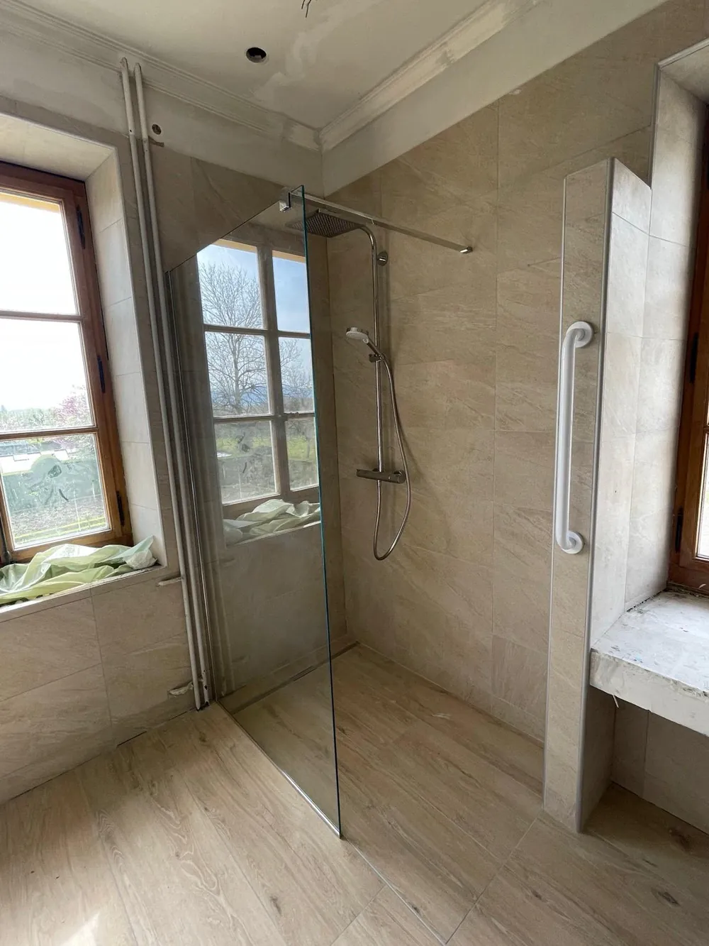 Douche à l'italienne vitrée dans une salle de bains claire.