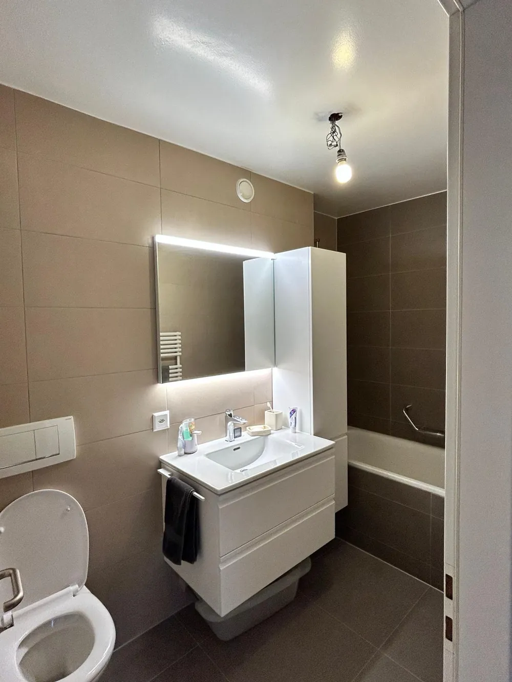 Salle de bains contemporaine, carrelage grand format et meuble suspendu.